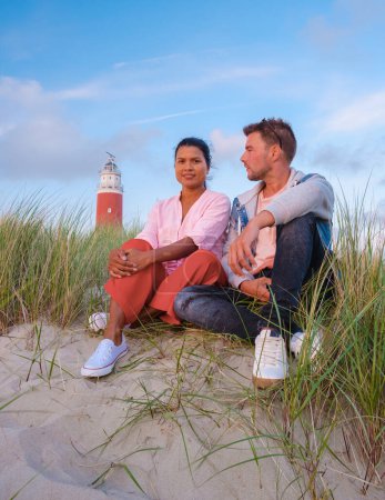 Téléchargez les photos : Phare Texel pendant le coucher du soleil Pays-Bas Île hollandaise Texel Hollande, le couple visite le phare, les hommes et les femmes en vacances Texel - en image libre de droit