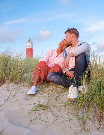 Photo for Texel lighthouse during sunset Netherlands Dutch Island Texel Holland, a couple visit the lighthouse, men, and woman on vacation Texel watching sunset by the lighthouse - Royalty Free Image