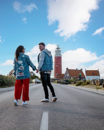 Foto de Una pareja visita el faro de la isla holandesa Texel, hombres y mujeres de vacaciones Texel - Imagen libre de derechos