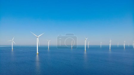 Foto de Parque de molinos de viento con nubes y un cielo azul, parque de molinos de viento en la vista aérea del océano con turbina eólica Flevoland Países Bajos Ijsselmeer. Energía verde - Imagen libre de derechos