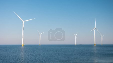Photo for Windmill park with clouds, windmill park in the ocean aerial view with wind turbine Flevoland Netherlands Ijsselmeer. Green energy - Royalty Free Image