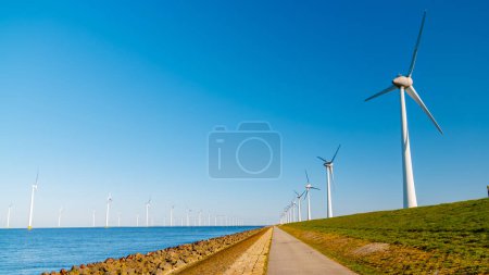 Foto de Parque de molinos de viento en alta mar con nubes y un cielo azul, parque de molinos de viento en la vista aérea del océano con turbina eólica Flevoland Países Bajos Ijsselmeer. - Imagen libre de derechos