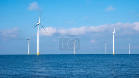 Photo for Windmill park with clouds and a blue sky, windmill park in the ocean aerial view with wind turbine Flevoland Netherlands Ijsselmeer. Green energy - Royalty Free Image