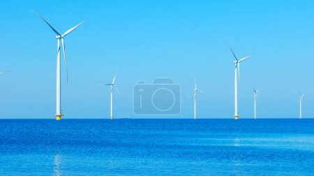 Téléchargez les photos : Parc éolien offshore avec nuages et un ciel bleu, parc éolien dans l'océan vue aérienne avec éolienne Flevoland Pays-Bas Ijsselmeer. Énergie verte - en image libre de droit