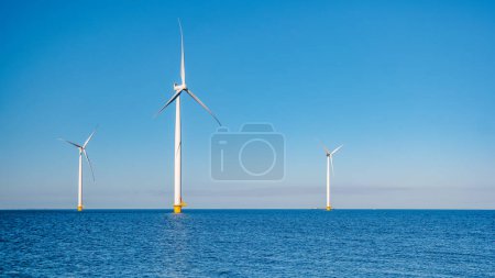 Téléchargez les photos : Parc éolien offshore avec nuages et un ciel bleu, parc éolien dans l'océan vue aérienne avec éolienne Flevoland Pays-Bas Ijsselmeer. Production d'énergie verte aux Pays-Bas - en image libre de droit