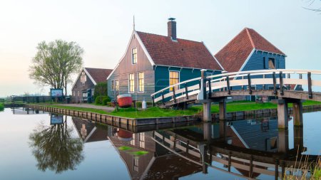 Téléchargez les photos : Coucher de soleil au village du moulin à vent Zaanse Schans au printemps aux Pays-Bas village hollandais avec fermes historiques en bois - en image libre de droit