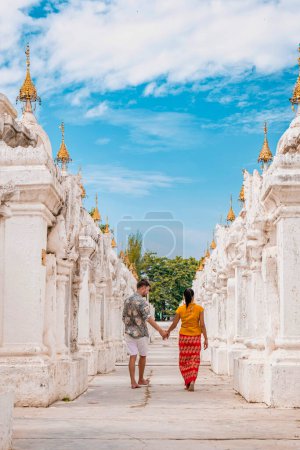 Téléchargez les photos : Pagode Kuthodaw à Mandalay, Birmanie Myanmar, heureux jeunes hommes et femmes en vacances au Myanmar marchant par la pagode temple blanc le plus grand livre dans le monde Asie - en image libre de droit