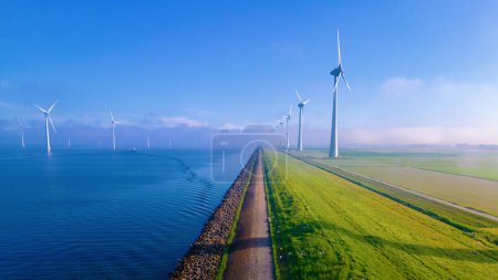 Photo for Windmill Park with a blue sky and green agricultural field Netherlands Europe the biggest wind park in the Netherlands - Royalty Free Image