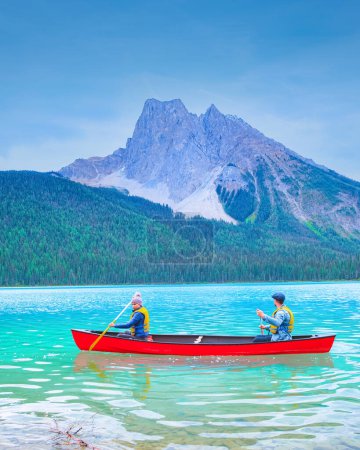 Téléchargez les photos : Couple dans un canot au lac Emerald Lake, parc national Yoho au Canada. hommes et femmes en canot - en image libre de droit