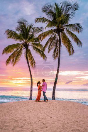 Foto de Santa Lucía Caribbean Island, una pareja de vacaciones de lujo en la isla tropical de Santa Lucía observando la puesta de sol en la playa con cocoteros - Imagen libre de derechos