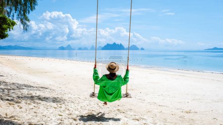 Photo for Woman on the beach of the tropical Island Naka Island near Phuket Thailand, the woman at a swing on the beach. Naka Island Phuket Thailand - Royalty Free Image
