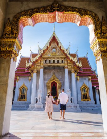 Téléchargez les photos : Wat Benchamabophit temple à Bangkok Thaïlande, Le temple de marbre à Bangkok. Femme asiatique avec un chapeau et des hommes européens visitant un temple, un couple en voyage à Bangkok - en image libre de droit