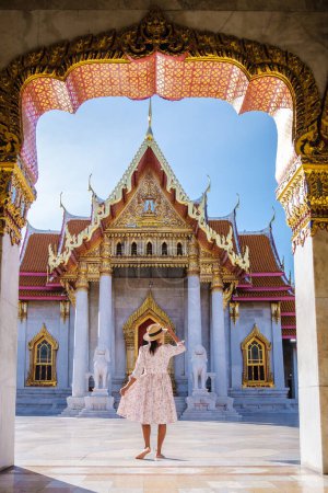 Photo for Wat Benchamabophit temple in Bangkok Thailand, The Marble temple in Bangkok. Asian woman with a hat visiting a temple, a women on a city trip in Bangkok - Royalty Free Image
