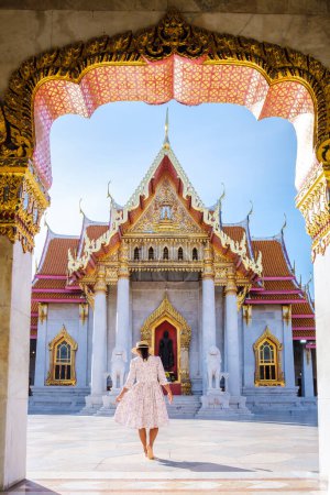 Photo for Wat Benchamabophit temple in Bangkok Thailand, The Marble temple in Bangkok. Asian woman with a hat visiting a temple, a women on a city trip in Bangkok - Royalty Free Image