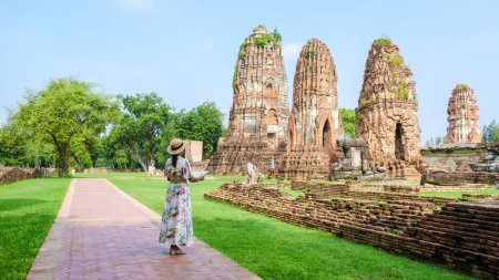 Photo for Ayutthaya Thailand, Wat Mahathat, women with a hat, and tourist maps visiting Ayutthaya Thailand. Tourists with a map of Thailand - Royalty Free Image