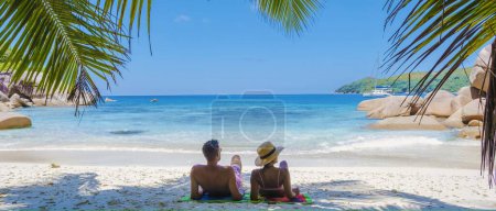 Foto de Praslin Seychelles tropical island with withe beaches and palm trees, couple of men and women mid age on vacation at Seychelles visiting the tropical beach Anse Lazio Praslin Seychelles. drone view - Imagen libre de derechos