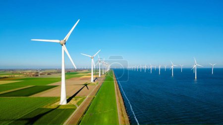 Foto de Parque de molinos de viento en alta mar con nubes y un cielo azul, parque de molinos de viento en la vista aérea del océano con turbina eólica Flevoland Países Bajos Ijsselmeer. Energía verde en los Países Bajos - Imagen libre de derechos