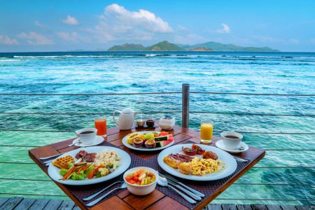Photo for Breakfast on the beach by the pool with a look over the ocean of La Digue Seychelles,tropical Island - Royalty Free Image