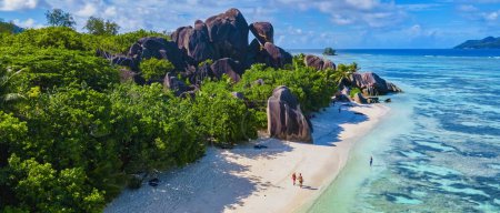 Photo for Anse Source d'Argent, La Digue Seychelles, a young couple of men and women on a tropical beach during a luxury vacation in Seychelles. Tropical beach Anse Source d'Argent, La Digue Seychelles - Royalty Free Image