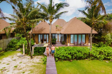 Téléchargez les photos : Un couple d'hommes et de femmes en vacances de luxe en Thaïlande dans un complexe 5 étoiles relaxant dans la piscine - en image libre de droit