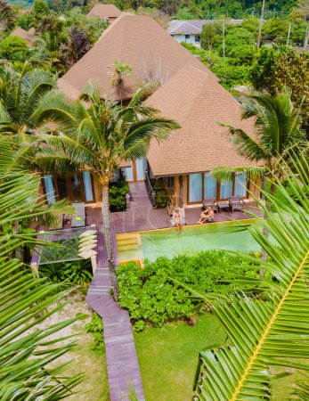 Téléchargez les photos : Un couple d'hommes et de femmes en vacances de luxe en Thaïlande dans un complexe 5 étoiles relaxant dans la piscine, hommes et femmes en vacances dans un complexe de luxe dans une forêt verdoyante de jungle de jardin - en image libre de droit