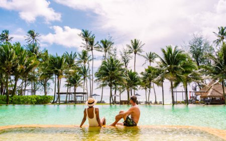 Téléchargez les photos : Piscine dans la jungle de Thaïlande, piscine dans la jungle de Thaïlande. couple d'hommes et de femmes dans la piscine à la plage par une journée ensoleillée - en image libre de droit