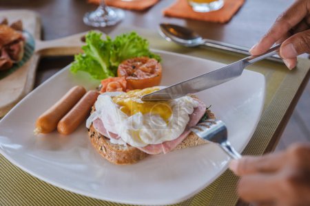 Téléchargez les photos : Oeuf poché pendant la table de petit déjeuner sur la plage de Koh Kood en Thaïlande, oeuf table de petit déjeuner benedict dans un hôtel de luxe - en image libre de droit