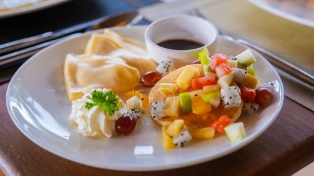 Téléchargez les photos : Crêpe aux fruits pendant la table de petit déjeuner sur la plage de Koh Kood en Thaïlande, table de petit déjeuner dans un hôtel de luxe - en image libre de droit