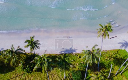 Foto de Ao Phrao Beach Koh Kood Island Thailand Trat, playa tropical con palmeras y un océano turquesa en un día soleado, pareja caminando en la playa de Ko Kut Island - Imagen libre de derechos