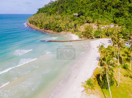 Téléchargez les photos : Ao Phrao Beach Koh Kood Island Thaïlande Trat, plage tropicale avec palmiers et une turque couleur océan par une journée ensoleillée, couple marchant sur la plage de Ko Kut Island pendant les vacances - en image libre de droit