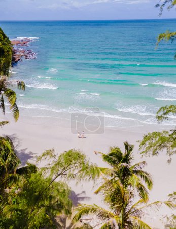 Foto de Vista a la playa entre palmeras con un dron, Koh Kood Island Tailandia Trat, pareja caminando en la playa de Ko Kut Island durante las vacaciones - Imagen libre de derechos