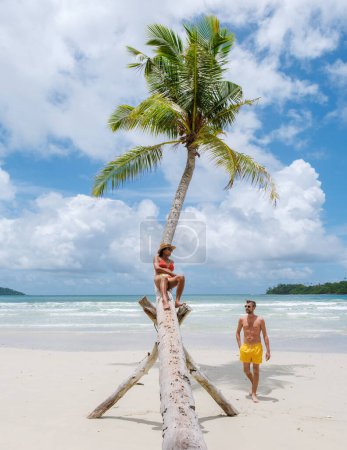 diverse multiracial couple on vacation at oh Kood Island Thailand Trat, a couple of men and women relaxing at a hanging palm tree on a sunny day 