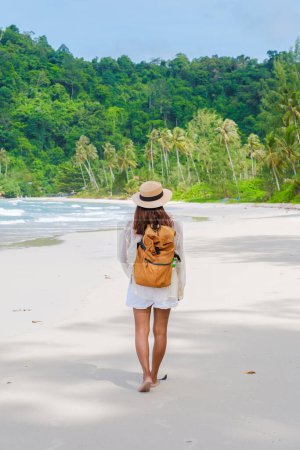 Foto de Mujer asiática con mochila caminando en la playa Koh Kood Island Thailand Trat, viajero caminando en la playa de la isla tropical Ko Kut Island - Imagen libre de derechos