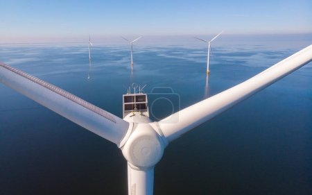 Foto de Turbina eólica en el océano, parque eólico en medio de un paisaje azul soleado, donde las turbinas elegantes abrazan la promesa de la energía renovable - Imagen libre de derechos