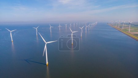 Foto de Parque de molinos de viento de pie en el mar en un día nublado. Turbinas eólicas situadas en el mar. - Imagen libre de derechos