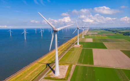 Foto de Turbina Energía Verde Electricidad, Molino de viento para la producción de energía eléctrica, Turbinas eólicas que generan electricidad en un campo agrícola verde en los Países Bajos por el lago Ijsselmeer - Imagen libre de derechos