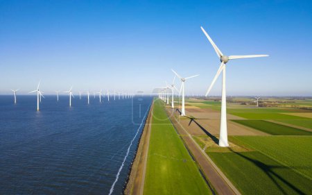 Téléchargez les photos : Turbine Green Energy Electricity, Moulin à vent pour la production d'électricité, éoliennes produisant de l'électricité sur un champ agricole vert aux Pays-Bas au bord du lac Ijsselmeer - en image libre de droit