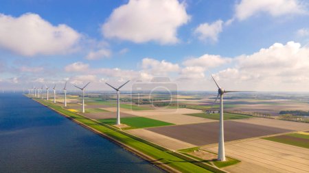 Foto de Turbina Energía Verde Electricidad, Molino de viento para la producción de energía eléctrica, Turbinas eólicas que generan electricidad en un campo agrícola verde en los Países Bajos junto al lago Ijsselmeer, energía verde - Imagen libre de derechos