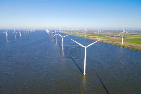 Foto de Ocean Wind Farm. Molino de viento granja en el océano. Turbinas eólicas marinas en el mar. Turbina eólica desde vista aérea. en los Países Bajos - Imagen libre de derechos