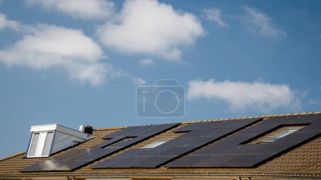 Téléchargez les photos : Maisons nouvellement construites avec des panneaux solaires fixés sur le toit, panneaux solaires sur un toit à pignon. Belle, grande maison moderne et énergie solaire. - en image libre de droit