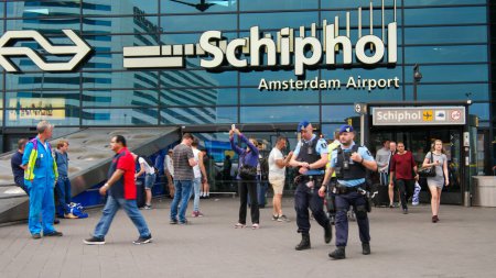 Photo for Amsterdam Airport Schipol Netherlands 6 July 2017, Police Marechaussee at Schiphol entrance, busy people during summer holiday Schiphol airport Amsterdam Netherlands, Dutch police Marechaussee - Royalty Free Image