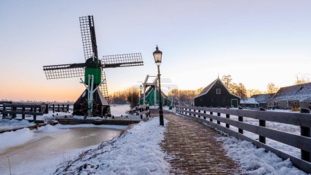 Foto de Zaanse Schans Países Bajos un pueblo molino de viento holandés durante una mañana de invierno con la antigua casa de madera holland pueblo - Imagen libre de derechos