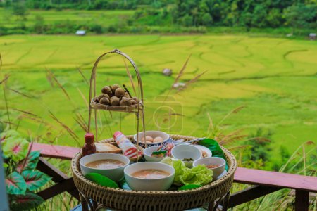 Téléchargez les photos : Soupe de riz le matin pour le petit déjeuner avec une rizière jaune vert à Sapan Bo Kluea Nan Thaïlande, une vallée verte avec des rizières vertes et des montagnes - en image libre de droit