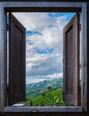 Téléchargez les photos : Une vue à travers une fenêtre en bois sur les montagnes verdoyantes des montagnes de Doi Chang de Chiang Rai Nord de la Thaïlande, vue sur la montagne naturelle sur Doi Chang, province de Chiang Rai, Thaïlande - en image libre de droit