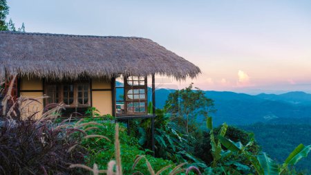 Foto de Casa de familia en las montañas Doi Chang de Chiang Rai norte de Tailandia, cabaña de madera de bambú en las montañas, cabaña al atardecer - Imagen libre de derechos