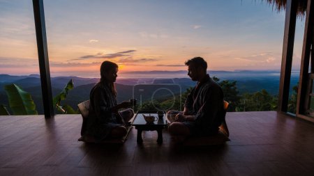 Foto de Una pareja de vacaciones en Tailandia despertando con café goteo en la mañana al amanecer, con una mirada a las montañas de Doi Chang Chiang Rai Tailandia - Imagen libre de derechos
