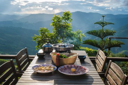 Photo for Dinner with a Thai BBQ at sunset in the mountains of Doi Chang Chiang Rai Thailand - Royalty Free Image