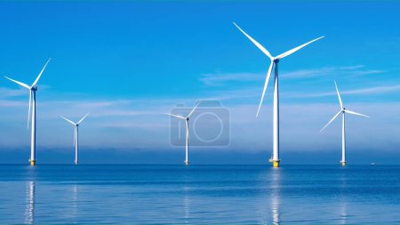 Photo for Offshore windmill park with clouds and a blue sky, windmill park in the ocean aerial view with wind turbine Flevoland Netherlands Ijsselmeer. Green Energy in the Netherlands - Royalty Free Image