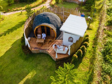 Photo for A couple of men and women camping in the mountains of Northern Thailand during vacation. Outdoor bathroom, and bathtub during sunset in the mountains at an igloo hut. drone aerial view - Royalty Free Image