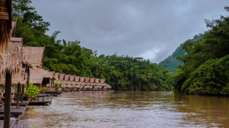 Téléchargez les photos : Maisons de plage tropicales sur la rivière Kwai en Thaïlande.Maison de radeau flottant en bois dans la rivière Kwai Kanchanaburi, Thaïlande pendant la saison des pluies - en image libre de droit